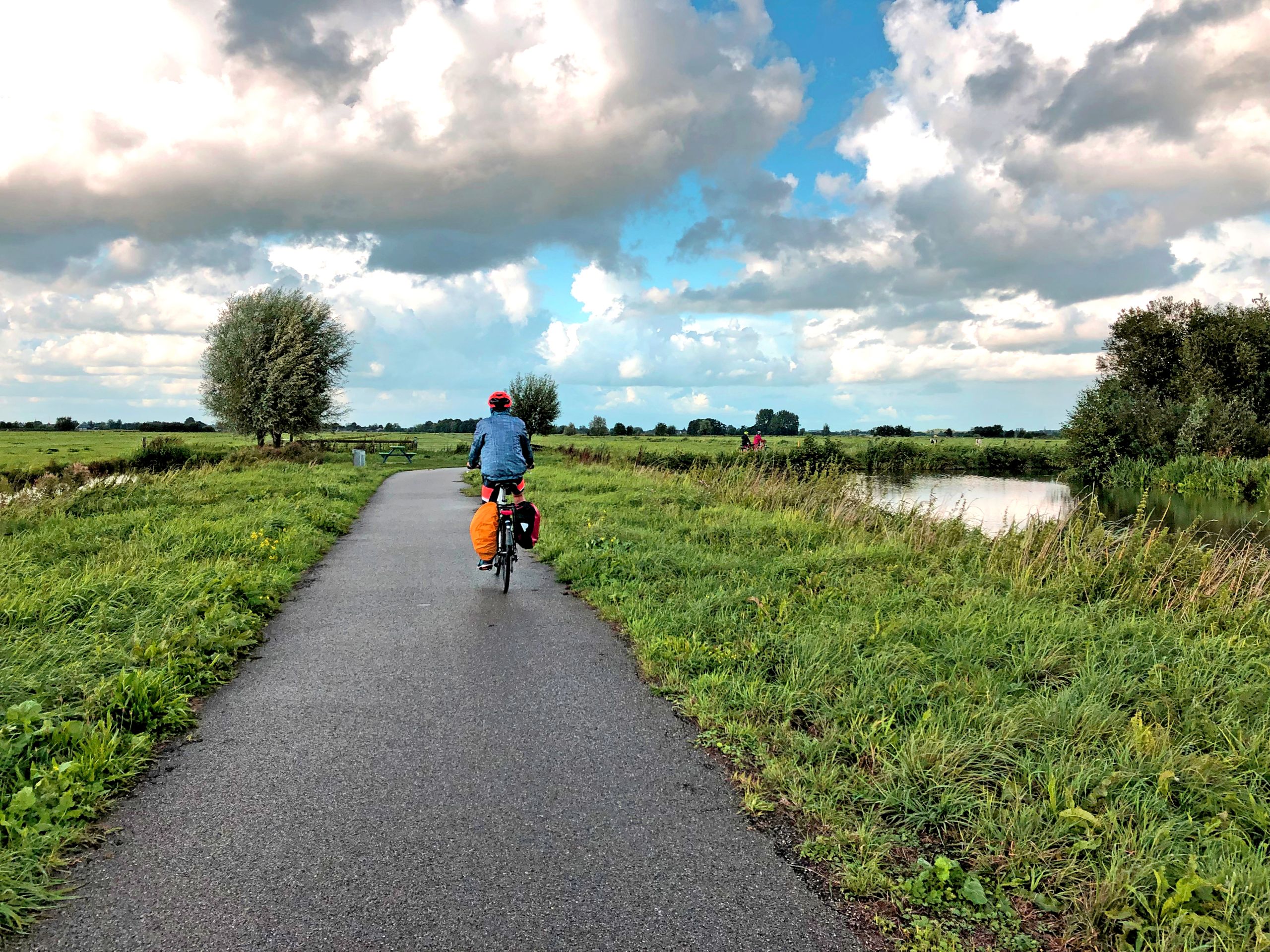 Ciclista su una ciclovia olandese tra il verde, vacanze bici e barca "Girolibero"